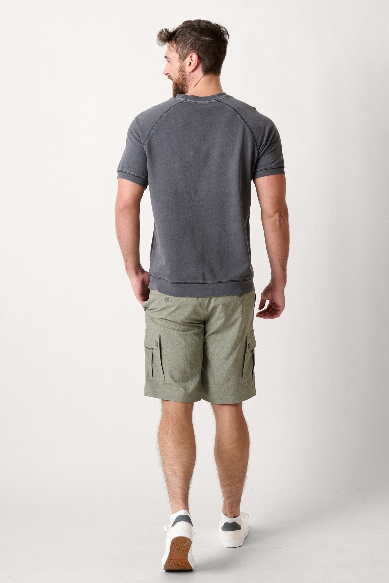 Male model dressed in hiking shorts for men with the WEARFIRST Go-To Short in Army Heather Green